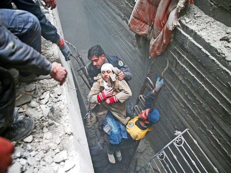 انتشال سورية فاقدة الوعي من تحت أنقاض منزلها في دوما أمس (رويترز)