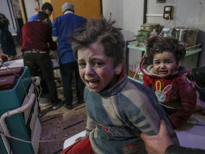 طفلان مصابان يبيكان داخل مستشفى ميداني في الغوطة بعد تعرض منزلهما للقصف (أي بي أيه)