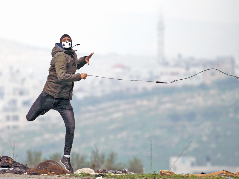 فلسطيني خلال مواجهات مع الجيش الإسرائيلي في الضفة الغربية أمس (أ ف ب)