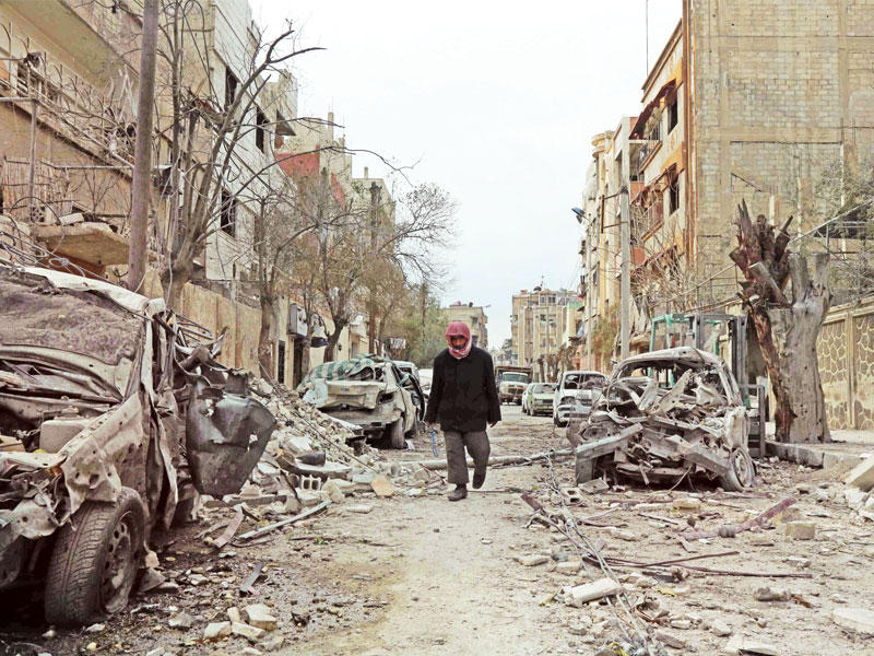 سوري يسير وسط مبان دمرتها غارات النظام على دوما أمس (أ ف ب)n