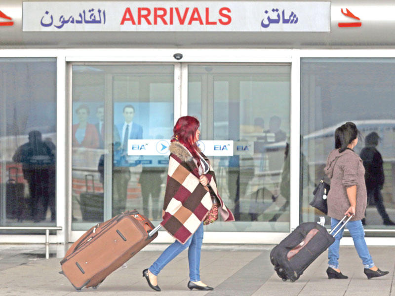 مسافرتان تمران أمام بوابة مطار أربيل أمس (أ ف ب)