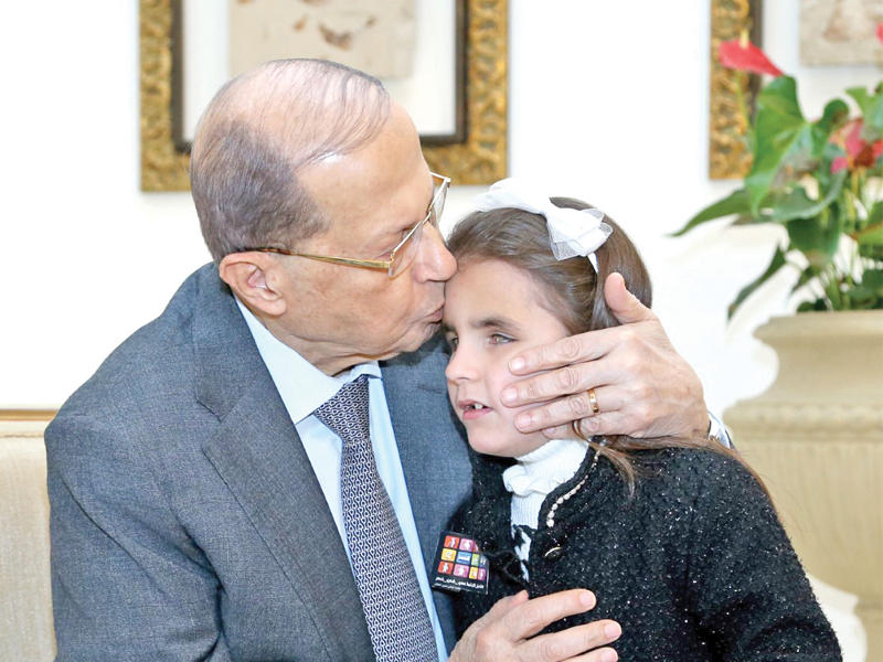 الرئيس اللبناني يحتضن طفلة من ذوي الاحتياجات الخاصة في القصر الجمهوري أمس (دالاتي ونهرا)