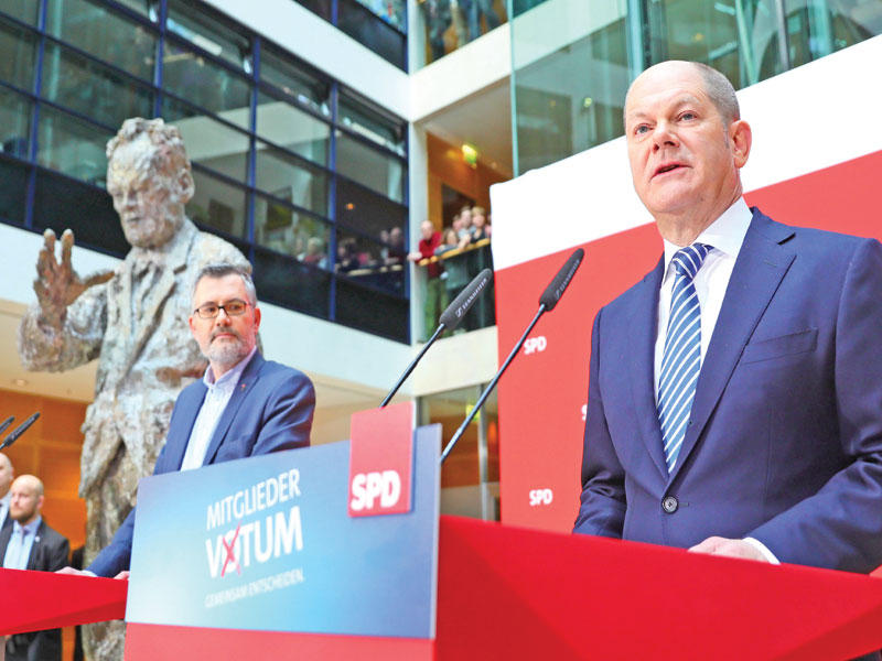 شولتز (إلى اليمين) معلناً نتيجة التصويت على التحاف مع ميركل أمسt (أ ف ب)