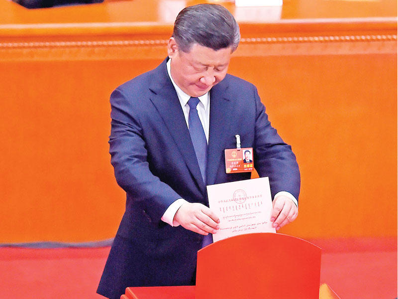 الرئيس شي جينبينغ مدلياً بصوته في قاعة الشعب الكبرى في بكين أمس (أ ف ب) 