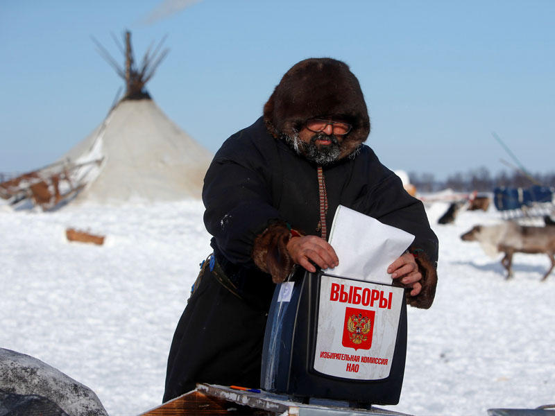 روسي يعيش في منطقة نائية يدلي بصوته بعد أن بدأت الانتخابات في بعض المناطق بسبب فارق التوقيت  في روسيا المترامية الأطراف (رويترز)
