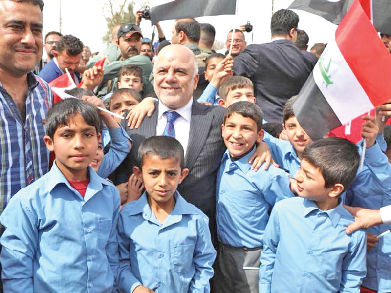 العبادي وسط فتية عراقيين خلال افتتاح الجسر القديم في الموصل أمس (مكتب رئاسة الحكومة) 