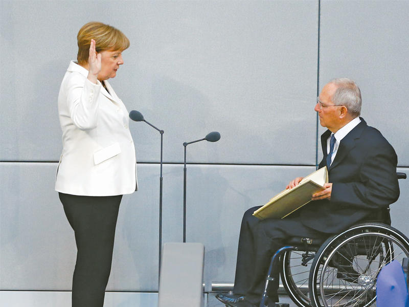 ميركل تؤدي اليمين في برلين أمس (رويترز)