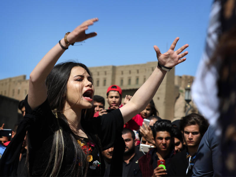 فتاة كردية وجموع أخرى خلال إحياء ذكرى حلبجة في أربيل أمسt(أ ف ب)