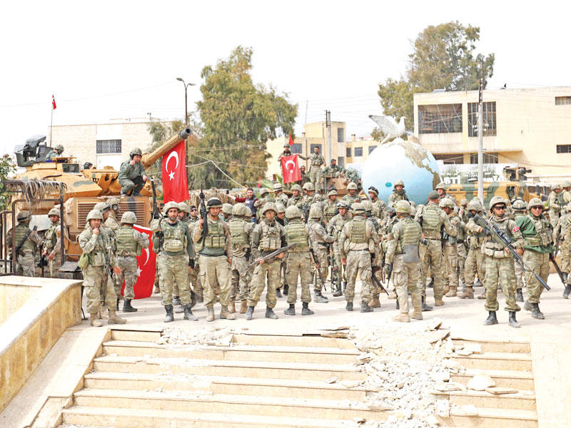 جنود أتراك ومقاتلون سوريون في قلب عفرين أمس (أ ف ب)