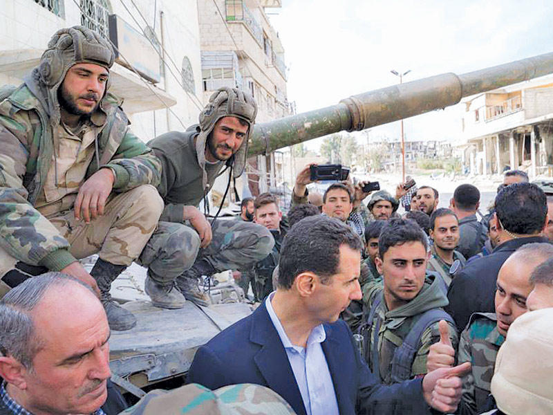 الأسد متوسطاً جنوده بالغوطة أمس (صفحة رئاسة الجمهورية على فيسبوك)