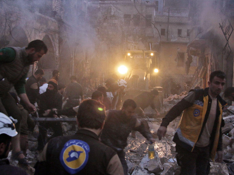 سوريون في موقع تعرض لغارة في إدلب مساء أمس الأول (أ ف ب)