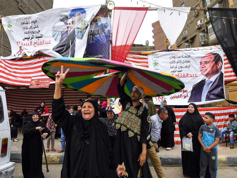 مصرية ترفع علامة النصر بمحيط لجنة انتخابية غرب الجيزة أمس (أ ف ب)