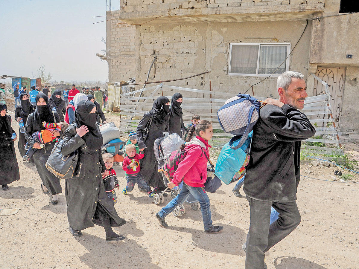 سوريون يغادرون دوما في 27 مارس (إي بي أيه)