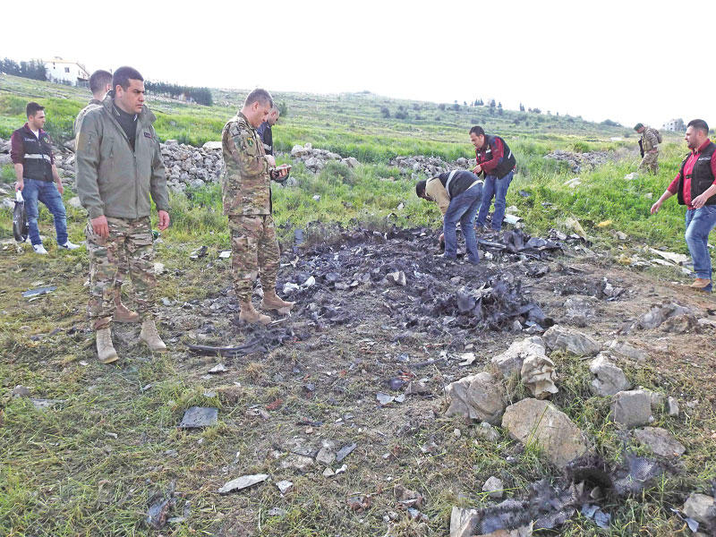 عناصر أمنية لبنانية تعاين موقع سقوط الطائرة الإسرائيلية في بيت حانون امس (أ ف ب)