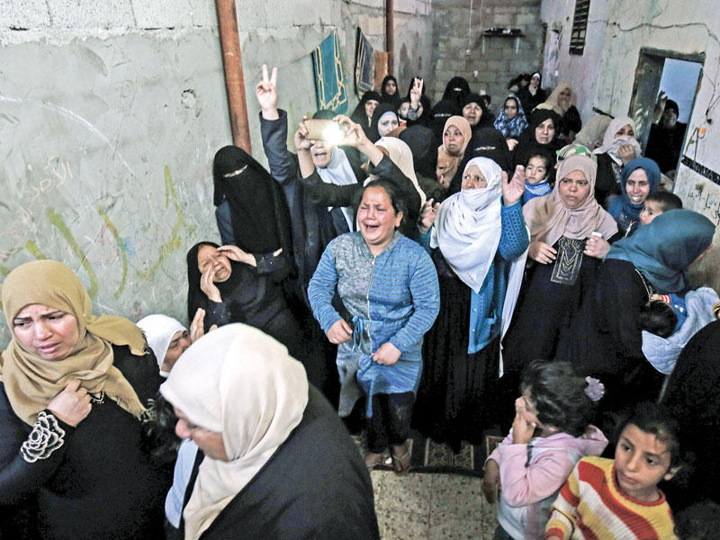 أقرباء إبراهيم أبوشاعر الذي سقط برصاص إسرائيلي خلال تشييعه في غزة أمس الأول t(أ ف ب)