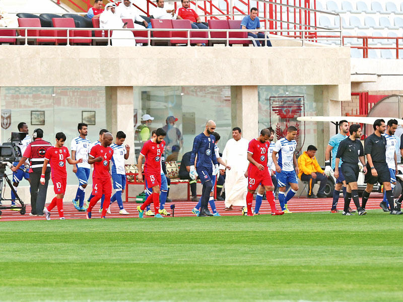 لاعبو الأبيض والجهراء خلال دخولهم أرضية الملعبn