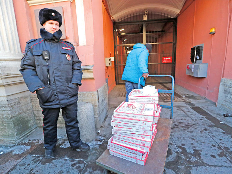 عامل يوصل البيتزا إلى القنصلية الأميركية في بطرسبورغ التي أخليت امس بالكامل من الموظفين (أي بي أيه) 