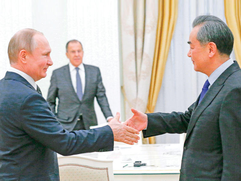 بوتين مستقبلاً وزير الخارجية الصيني في الكرملين ويبدو لافروف في الخلفية امس (أ ف ب)