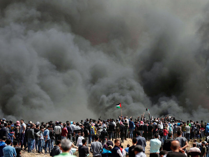 الدخان المتصاعد من حرق الإطارات يغطي سماء غزة أمس (أ ف ب)