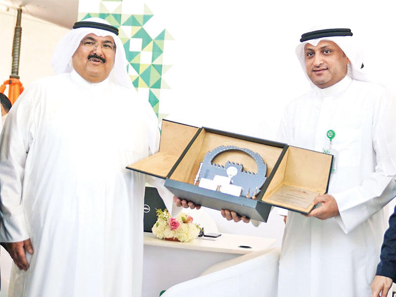 محمد الفارس، يتسلم درع التكريم من بندر الراشد