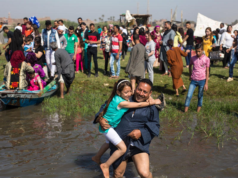 مصريون على ضفة نهر النيل احتفالا بشم النسيم في المنيا أمس (أ ف ب)