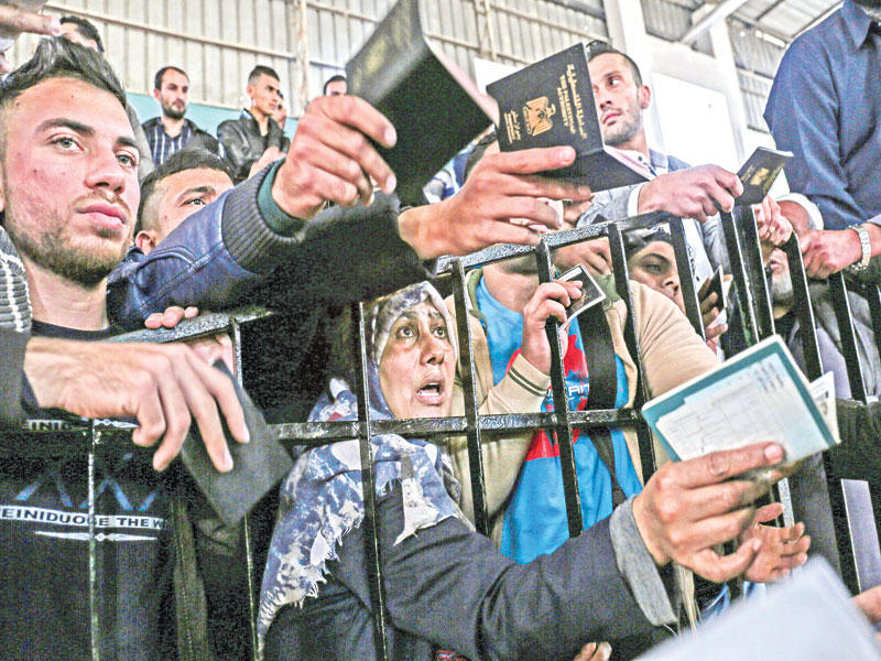 فلسطينيون يحاولون السفر إلى مصر عبر معبر رفح أمس (أ ف ب)