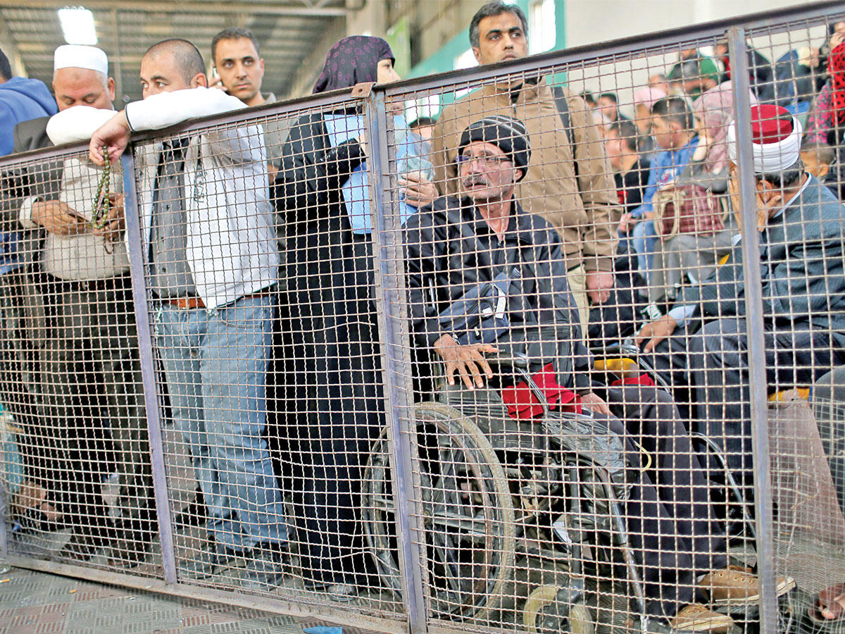 فلسطينون بانتظار السماح لهم بالسفر بعد فتح معبر رفح البري بين سيناء وقطاع غزة أمس الأول (رويترز)