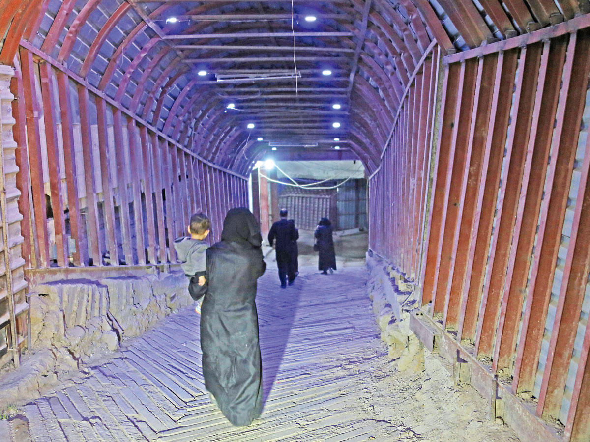 امرأة سورية تمر أمس في نفق شيدته فصائل المعارضة تحت الغوطة    (أ ف ب)