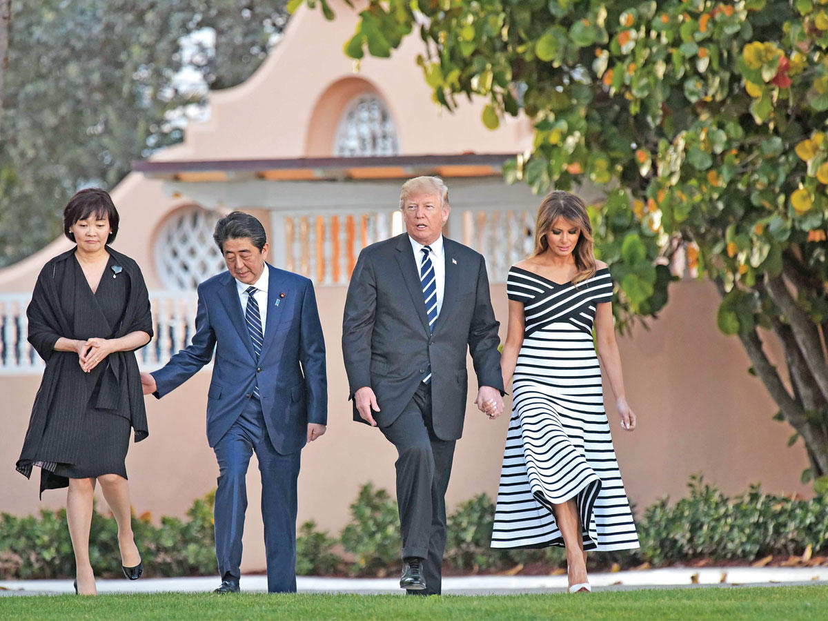 ترامب وزوجته في جولة بحديقة منزلهما الفخم في مارا لإغو مع رئيس الوزراء الياباني وزوجته (أ ف ب)