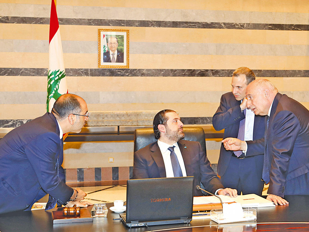 باسيل خلف الحريري الذي يستمع إلى بعض الوزراء على هامش جلسة الحكومة أمس (دالاتي ونهرا)