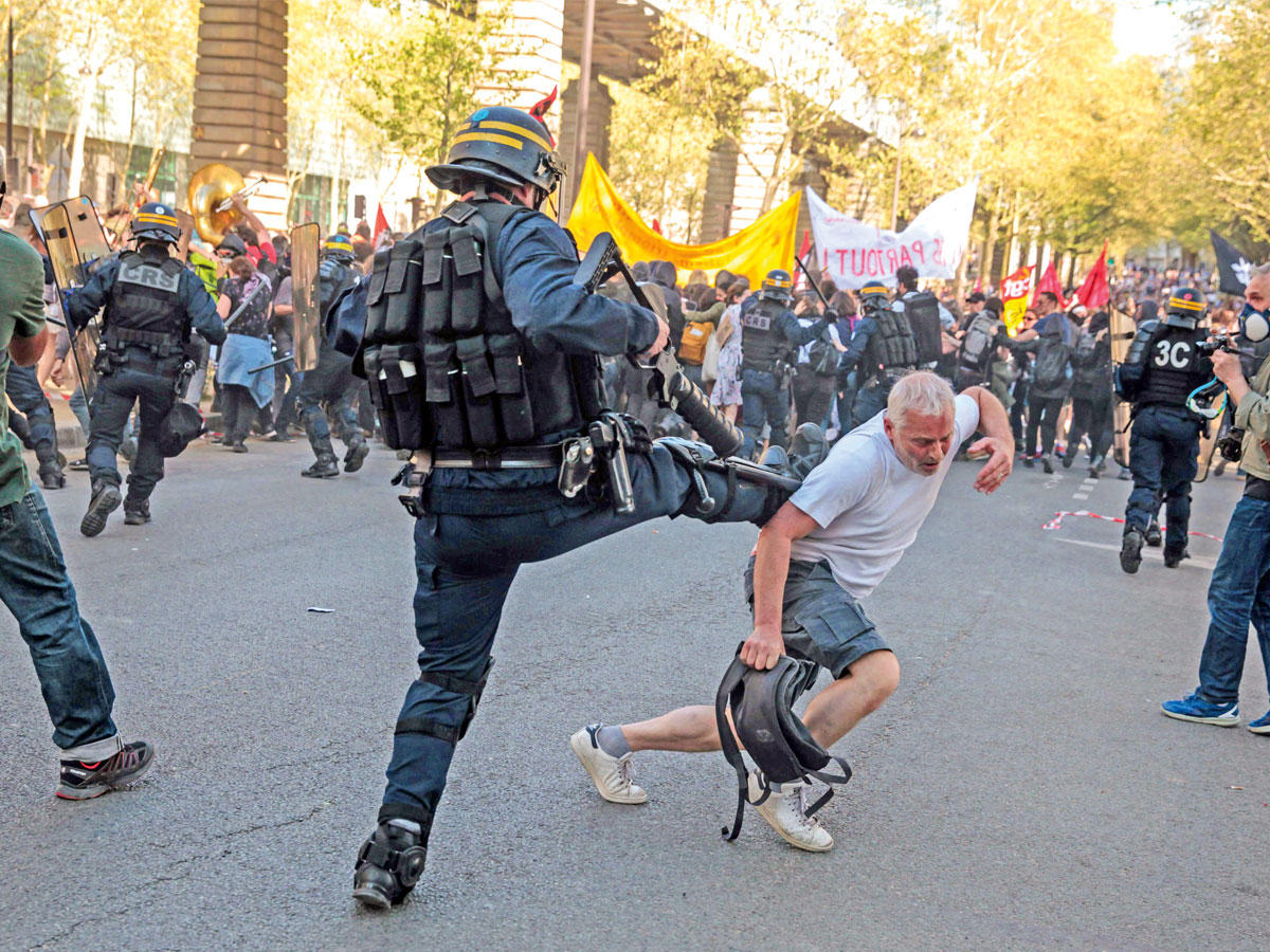  شرطي يركل متظاهراً في باريس أمس الأول (أ ف ب)