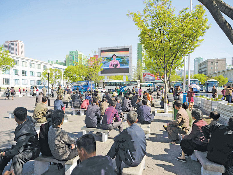 كوريون شماليون يشاهدون اجتماع الحزب الحاكم على شاشة عملاقة في احد شوارع بيونغ يانغ أمس (أ ف ب)