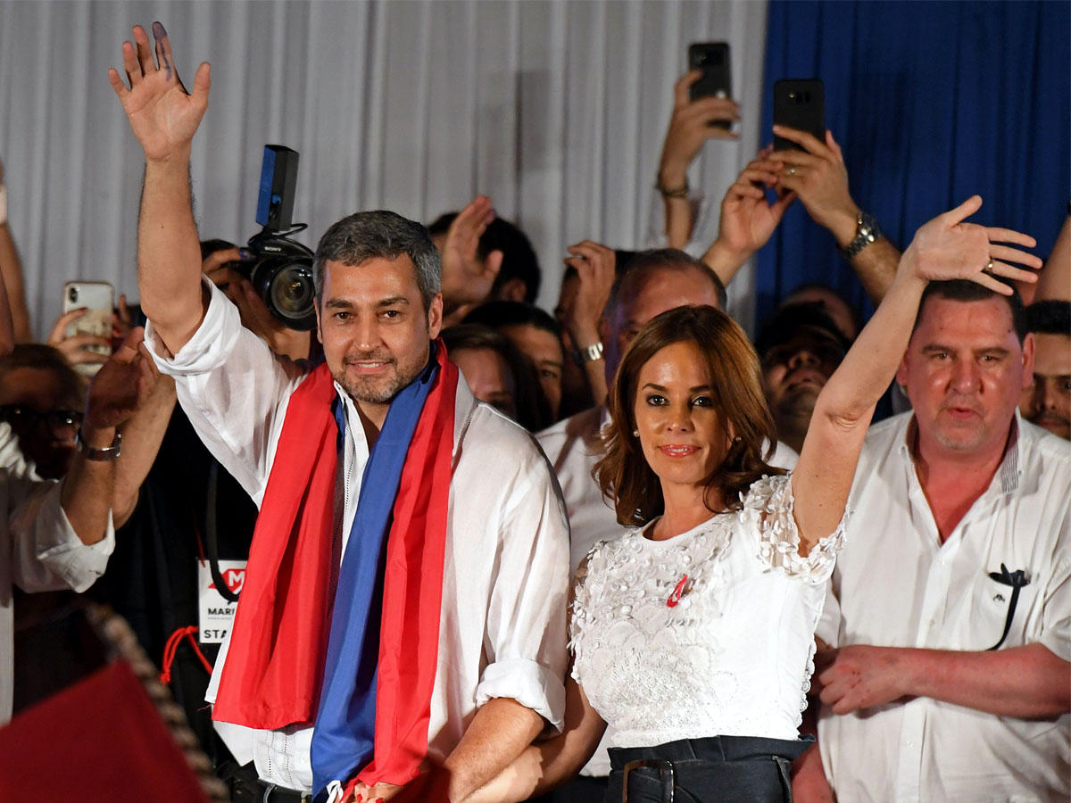 الرئيس الجديد في باراجواي ومرشح حزب كولورادو لحزب كولورادو ، ماريو عبدو بينيتيز ، إلى جانب زوجته سيلفانا لوبيز موريرا ، يلوحان أمام الحشد في مقر حزب بارتيدو كولورادو في أسونسيون