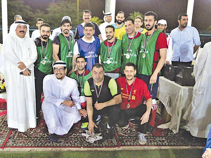 رضا يتوسط الفريق الفائز بكأس وزارة الصحة الأولى لكرة القدم