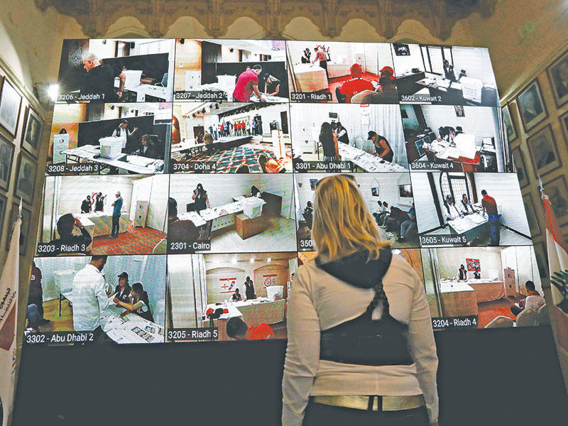 لبنانية تتابع الاقتراع من شاشات وزارة الخارجية أمس (ا ف ب)