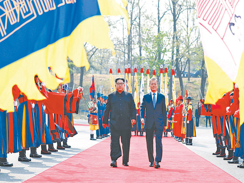  الزعيمان يستعرضان فرقة عسكرية بأزياء تقليدية في قرية بانمونجوم أمس t(أ ف ب)