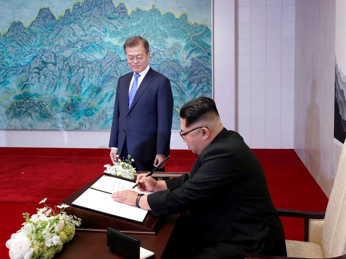 كيم يوقع بلوحة الشرف في بانمونجوم بحضور مون أمس (رويترز)n