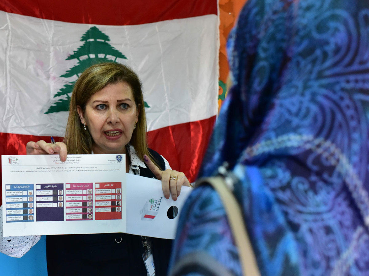 مسؤولة تشرح لناخبة لبنانية كيفية التصويت في الانتخابات النيابية في إحدى مدارس أبيدجان أمس      (أ ف ب)