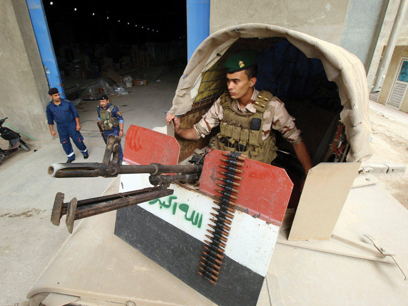 جنود عراقيون يحرسون مخزناً يحوي صناديق الاقتراع في البصرة (رويترز)