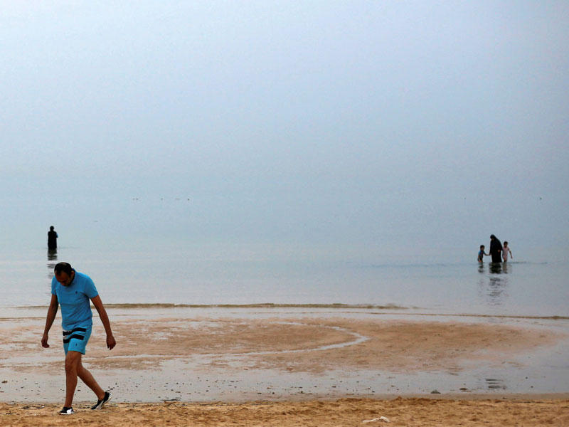 مصريون على شاطئ العين السخنة في خليج السويس (رويترز)