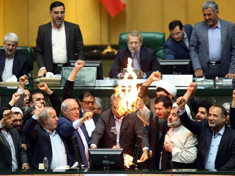 نواب إيرانيون يحرقون علما أميركيا ونسخة من الاتفاق النووي تحت قبة البرلمان في طهران أمس (ارنا)