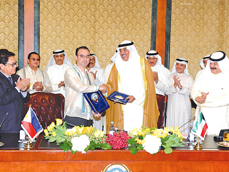 الخالد مصافحاً كايتانو بعد توقيع اتفاقية «العمالة المنزلية» أمس