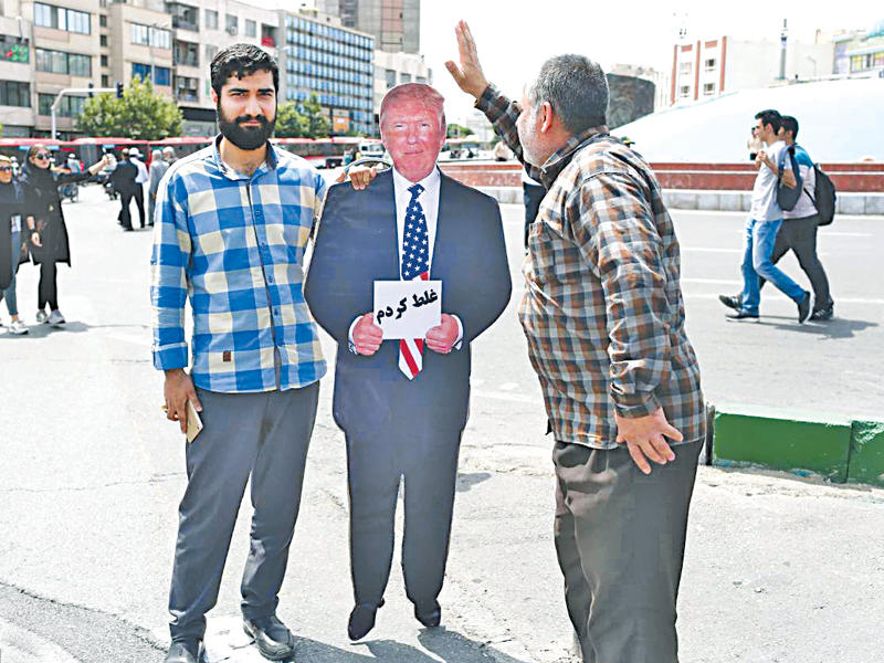 إيرانيان يقفان إلى جانب مجسم يمثل ترامب يحمل ورقة كتب عليها «لقد ارتكبت خطأ» (إرنا)