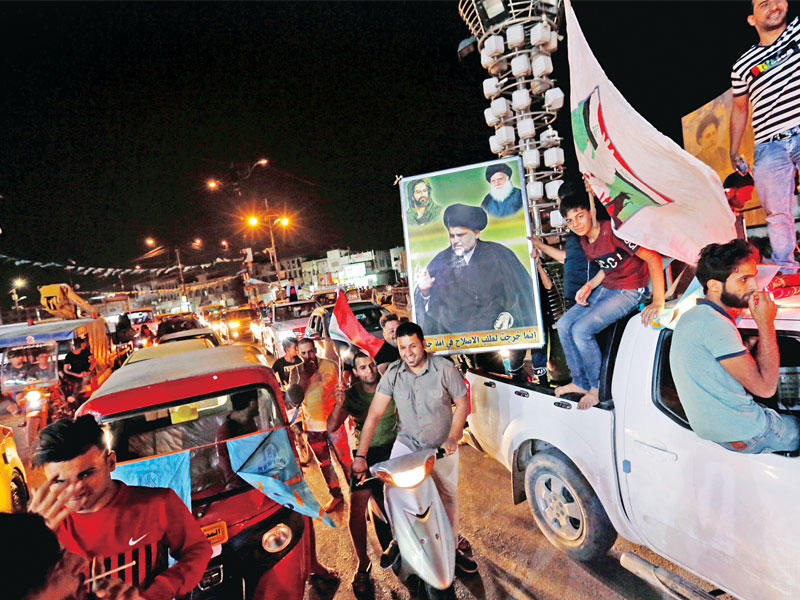 عراقيون يحتفلون بفوز قائمة «سائرون» وسط بغداد مساء أمس الأول (رويترز)