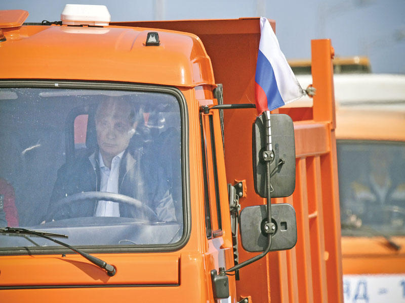  بوتين يقود الشاحنة فوق الجسر الذي افتتح أمس (رويترز)