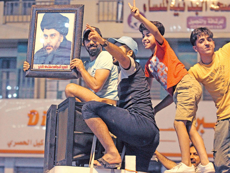 عراقيون يحملون صور الصدر في بغداد (أ ف ب)