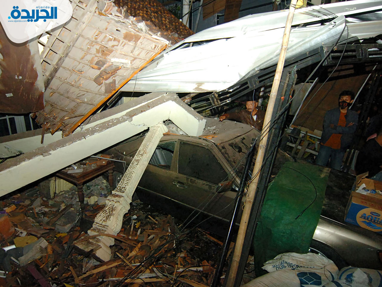 أحد المنازل والسيارات المتضررة من الحادث