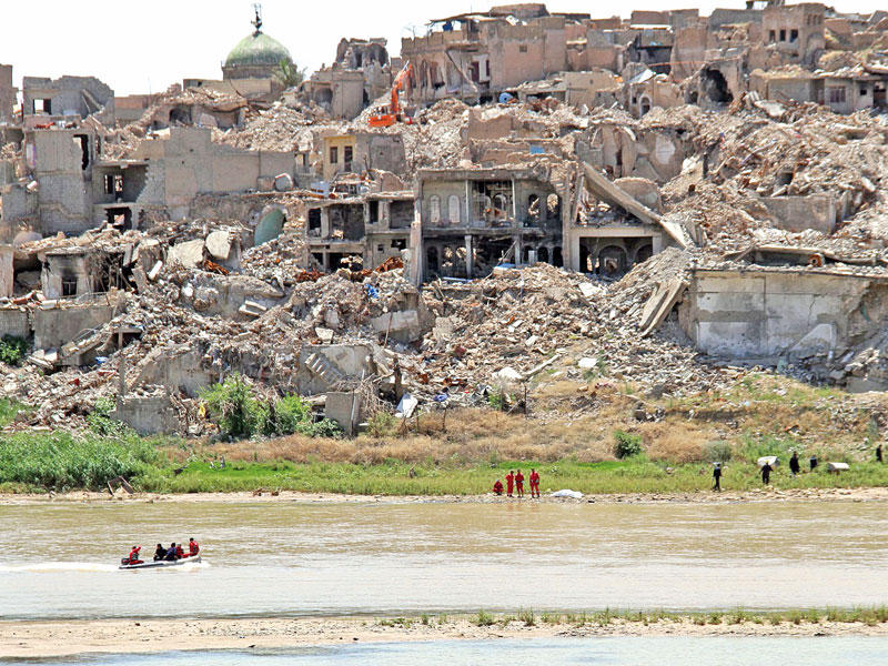 موظفون مدنيون لا يزالون يبحثون عن جثث مقاتلين لـ «داعش» ومدنيين في دجلة وتحت ركام الحي القديم بالموصل بعد 10 أشهر من تحرير المدينة (أ ف ب)