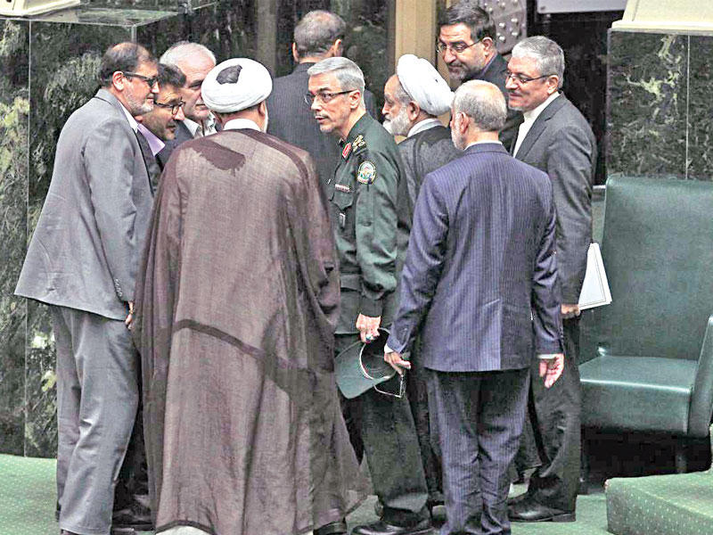 نواب يلتفون حول رئيس أركان الجيش الإيراني داخل مقر مجلس الشورى في طهران أمس t(ارنا)