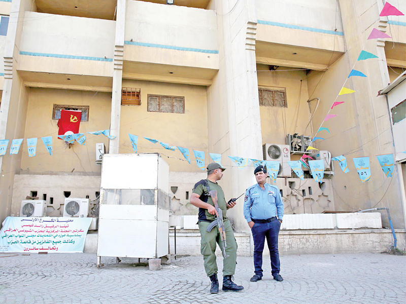 جندي وشرطي أمام مقر الحزب الشيوعي بساحة الأندلس في بغداد أمسt(أ ف ب)